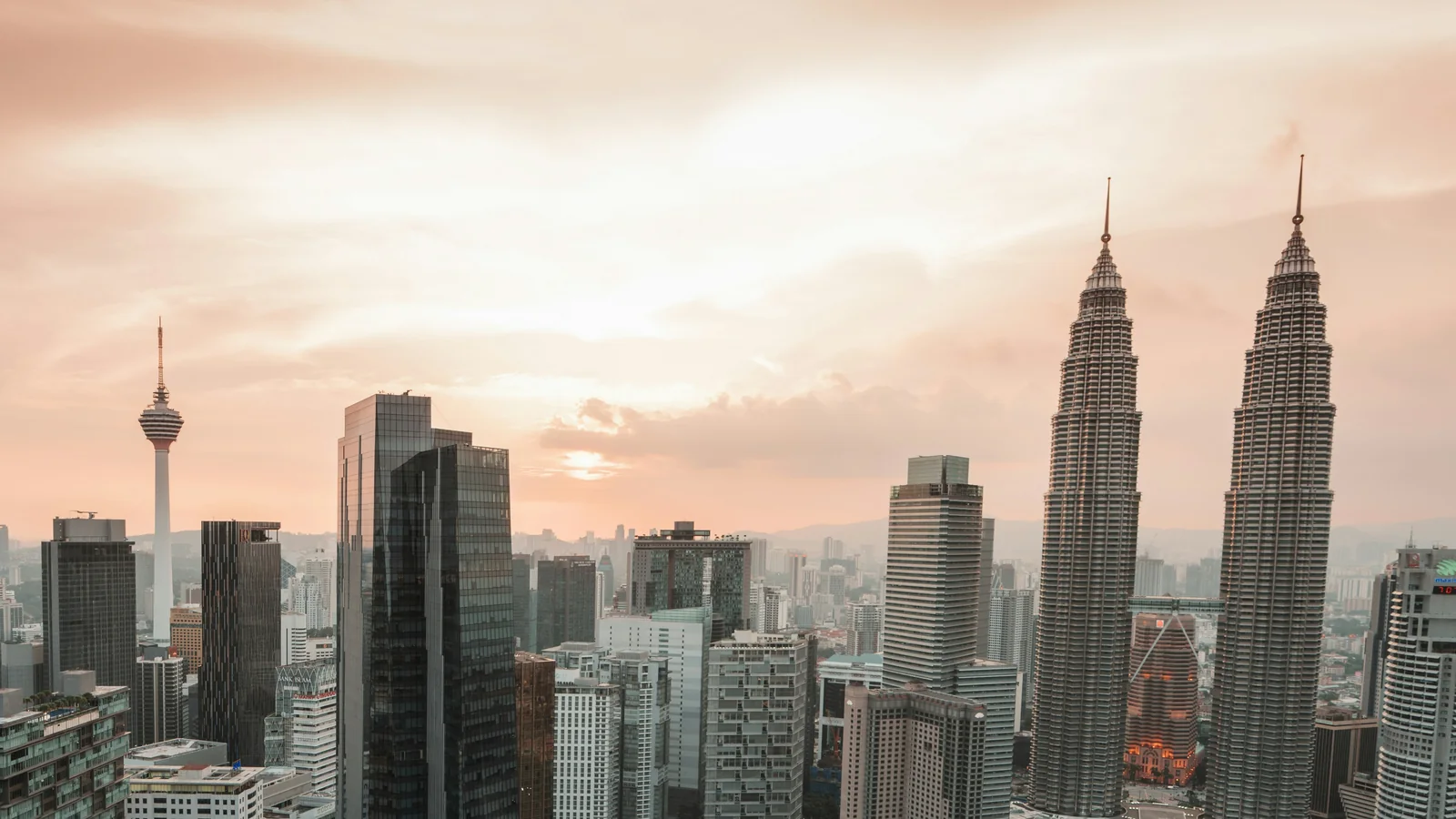 Petronas Twin Towers and KL Tower at sunset, seen from a rooftop in Kuala Lumpur city centre