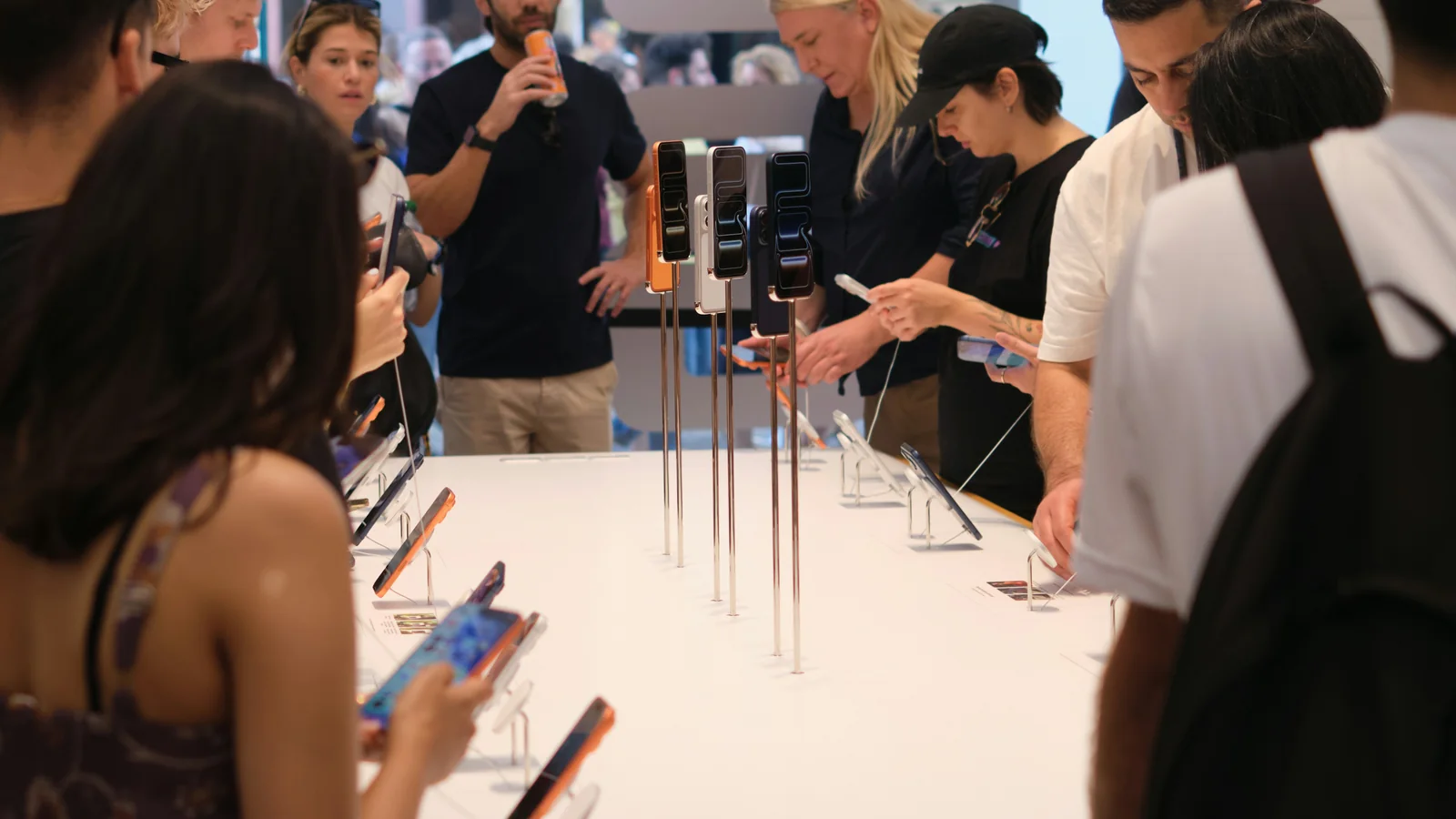 Guests trying new devices at a hands-on demo table during a product launch